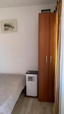 a bedroom with a bed and a wooden cabinet at Apartmani Green Olive in Bar, Susanj