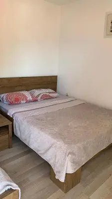 a bedroom with a large bed with red and white pillows at Apartmani Green Olive in Bar, Susanj