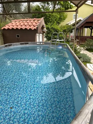 a large pool with blue water in a yard at Villa Green Olive Bar in Bar, Susanj