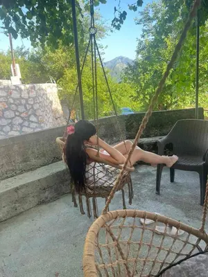 a woman is sitting in a swing at Old wine in Virpazar