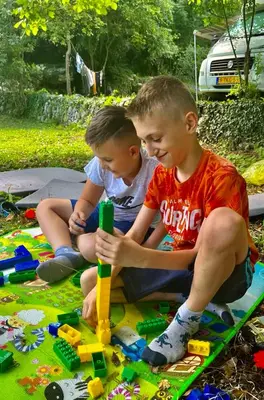two boys sitting on the ground playing with legos at Old wine in Virpazar