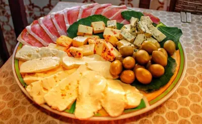 a plate of cheese and other foods on a table at Old wine in Virpazar