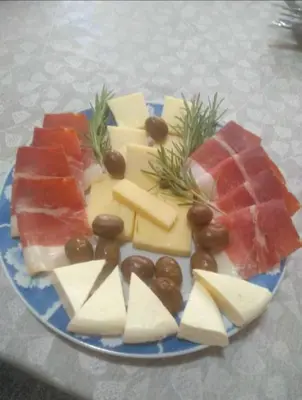 a blue plate with different types of cheese and meats at Old wine in Virpazar