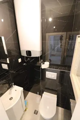 a bathroom with a white toilet and a sink at Apartment Sandrita in Kotor