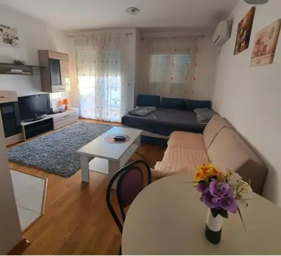 a living room with a couch and a table at City kvart apartman in Podgorica