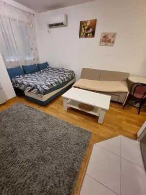 a living room with two beds and a table at City kvart apartman in Podgorica