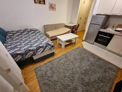 a small room with a bed and a kitchen at City kvart apartman in Podgorica
