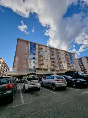 a parking lot with cars parked in front of a building at City kvart apartman in Podgorica