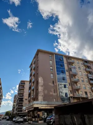 a tallartment building with a cloudy sky in the background at City kvart apartman in Podgorica