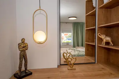 a room with a statue and a mirror and a bedroom at N&N Lux Guest house in Bar