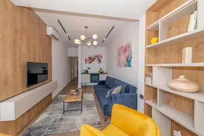a living room with a blue couch and a tv at N&N Lux Guest house in Bar