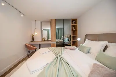 a bedroom with a large bed and a desk at N&N Lux Guest house in Bar
