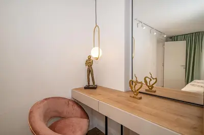 a bathroom with a pink chair and a mirror at N&N Lux Guest house in Bar