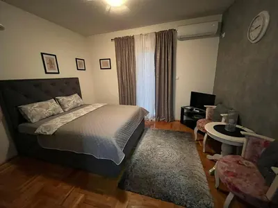 a bedroom with a bed and a table and a chair at Studio Place 8 in Podgorica