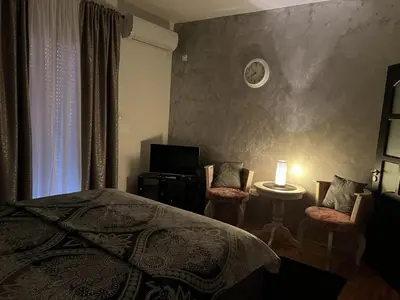 a bedroom with a bed and two chairs and a table at Studio Place 8 in Podgorica