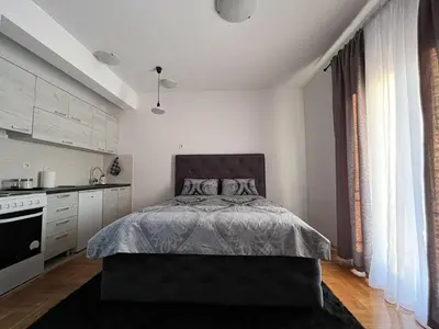 a bedroom with a bed and a kitchen at Studio Place 8 in Podgorica