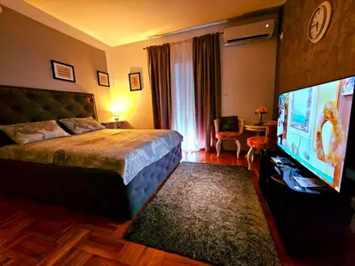 a bedroom with a bed and a flat screen tv at Studio Place 8 in Podgorica