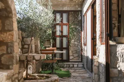 an entrance to a stone house with a door and a bench at Mahakala Center in Petrovac na Moru