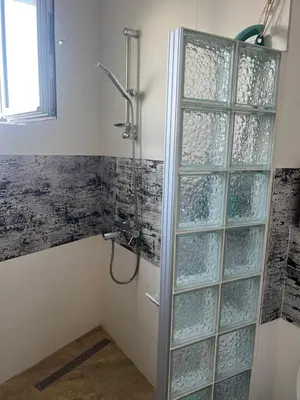 a shower with glass doors in a bathroom at Mahakala Center in Petrovac na Moru
