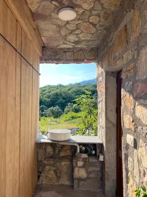 a bathroom with a sink in a stone wall at Mahakala Center in Petrovac na Moru