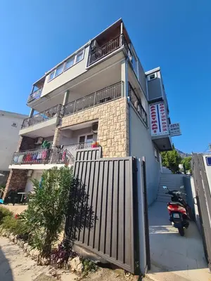 a building with a gate and a motorcycle parked in front at Apartments Bulatović in Bar