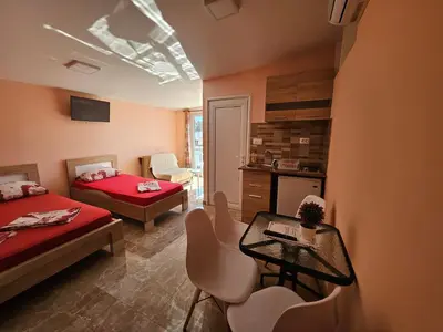 a bedroom with two beds and a table and chairs at Apartments Bulatović in Bar