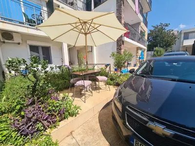 a car parked next to a table with an umbrella at Apartments Bulatović in Bar
