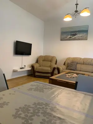a living room with two chairs and a flat screen tv at Duraku Apartment in Ulcinj