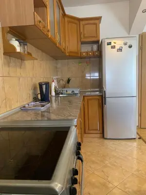a kitchen with a white refrigerator and wooden cabinets at Duraku Apartment in Ulcinj