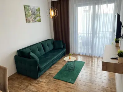 a living room with a green couch and a table at Vila Kollari in Ulcinj