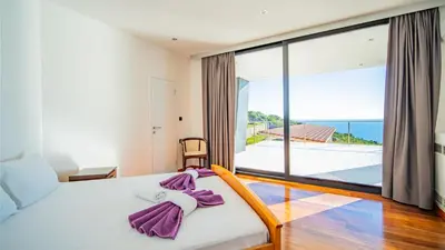 a bedroom with a bed with a view of the ocean at Villa Harizma in Budva
