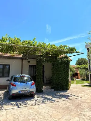 a car parked in front of a house at El Sol Apartmani in Bar