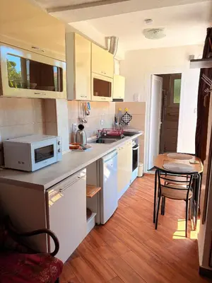 a kitchen with white cabinets and a microwave at El Sol Apartmani in Bar