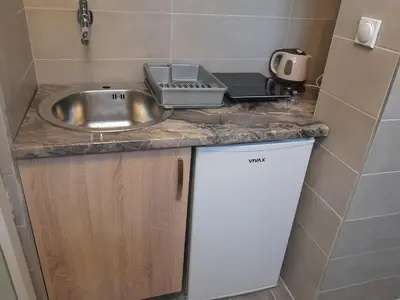 a kitchen counter with a sink and a laptop on it at Apartmani Jacimovic in Čanj