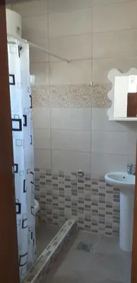 a bathroom with a shower curtain and a sink at Apartmani Jacimovic in Čanj
