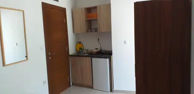 a kitchen with wooden cabinets and a counter top at Apartmani Jacimovic in Čanj