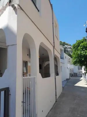 a white building with arches on the side of it at Apartmani Jacimovic in Čanj