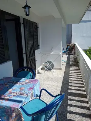 a table and chairs on the balcony of a house at Vesela vila in Sutomore