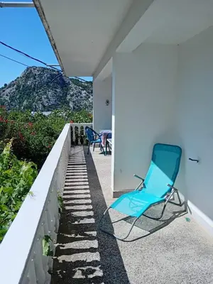 a blue chair sitting on the porch of a house at Vesela vila in Sutomore