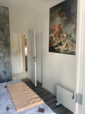 a bedroom with a painting hanging on the wall at Apartman Lara in Sveti Stefan
