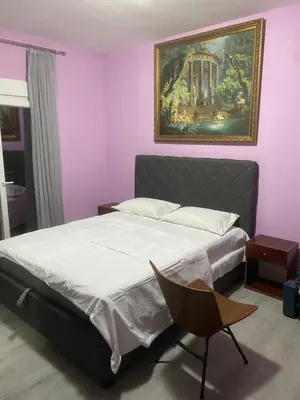 a bedroom with a bed and a painting on the wall at Apartman Lara in Sveti Stefan
