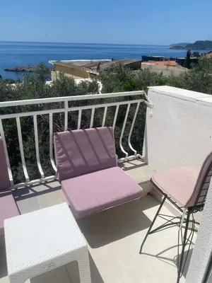 a balcony with two chairs and a table at Apartman Lara in Sveti Stefan