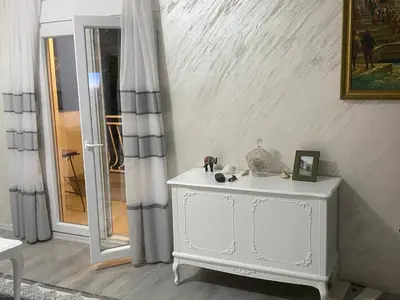 a white dresser in a room with a window at Apartman Lara in Sveti Stefan