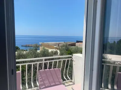 a balcony with a chair and a view of the ocean at Apartman Lara in Sveti Stefan