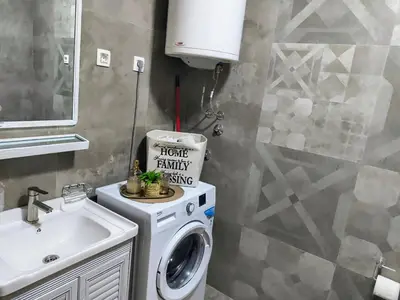 a bathroom with a washing machine and a sink at Podgorica apartman in Podgorica