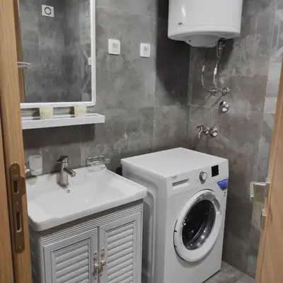a bathroom with a washing machine and a sink at Podgorica apartman in Podgorica