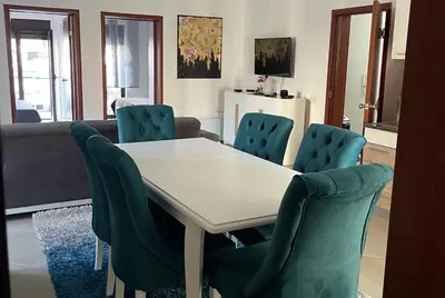 a dining room with a white table and chairs at 3 Bedroom Apartment with pool in Čeluga