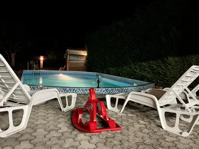 a group of lawn chairs and a swimming pool at 3 Bedroom Apartment with pool in Čeluga