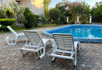 three lawn chairs sitting next to a swimming pool at 3 Bedroom Apartment with pool in Čeluga