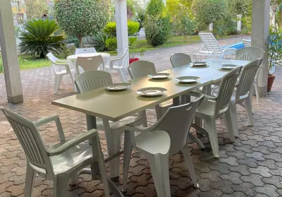 a wooden table and chairs on a patio at 3 Bedroom Apartment with pool in Čeluga
